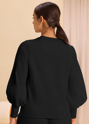 A model showcasing the back pose of a trendy black sweatshirt with long sleeves and puffed shoulders, combining comfort and style effortlessly
